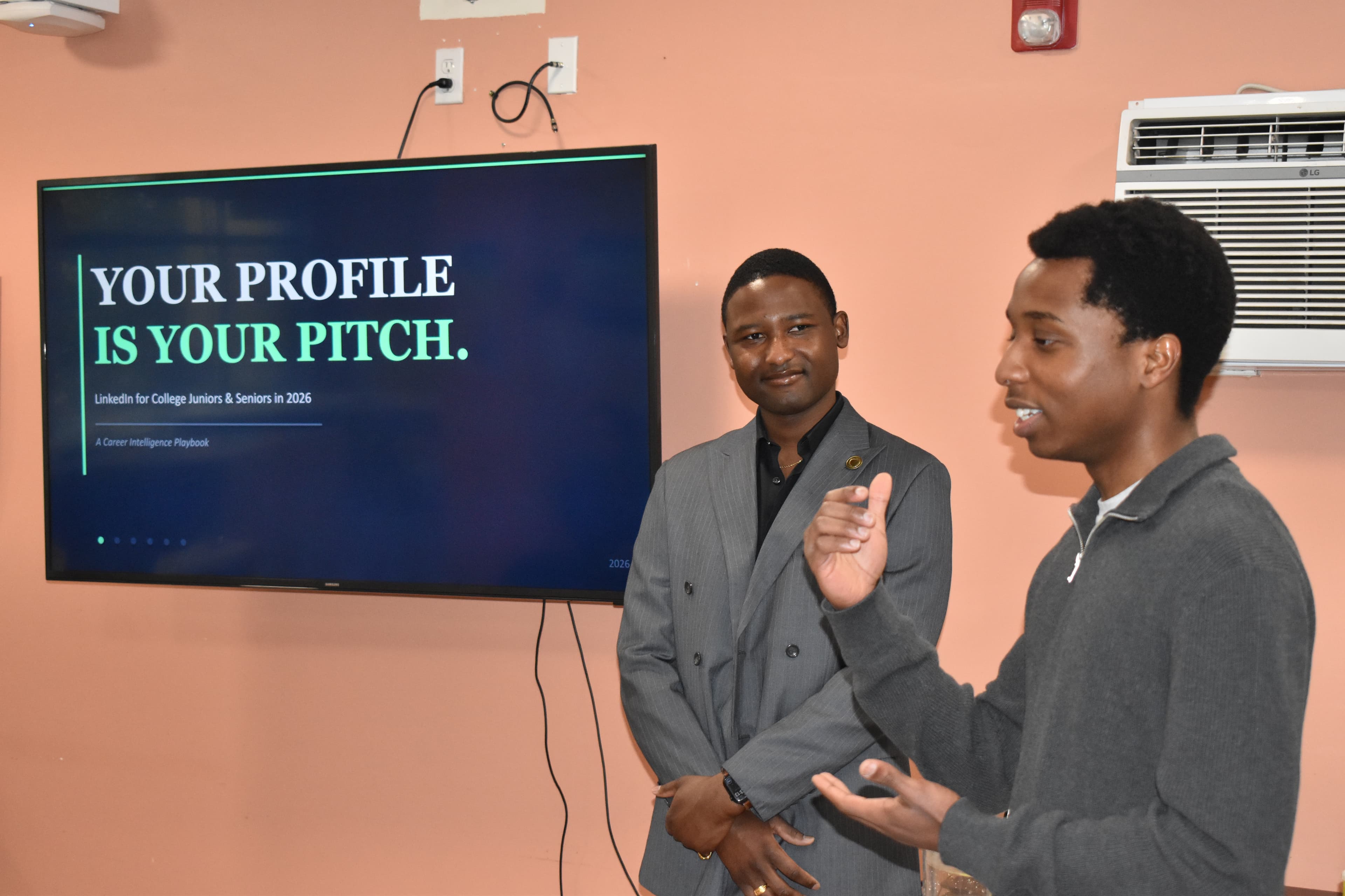 Two people presenting beside a screen reading Your profile is your pitch