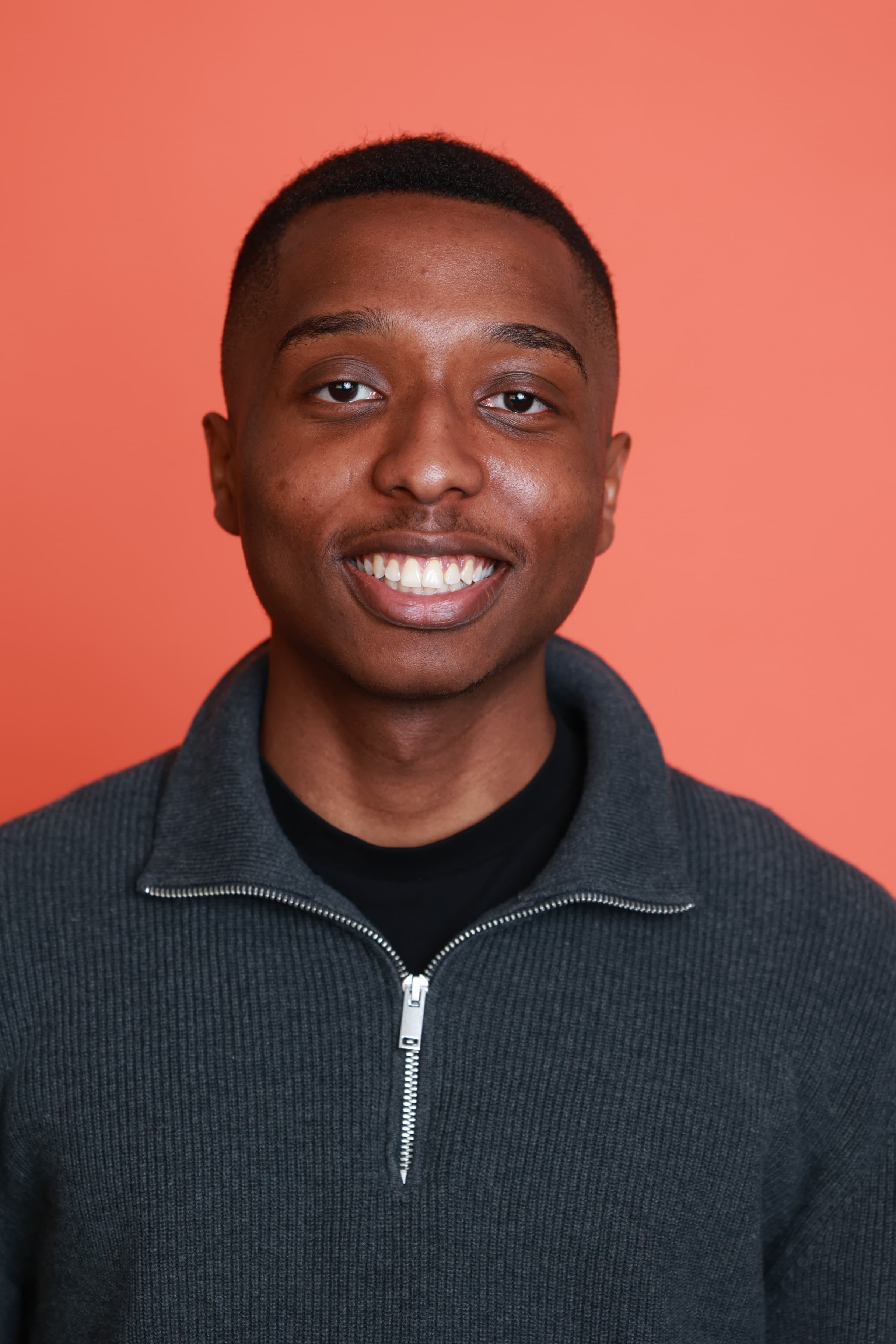 Portrait of me smiling against a coral background
